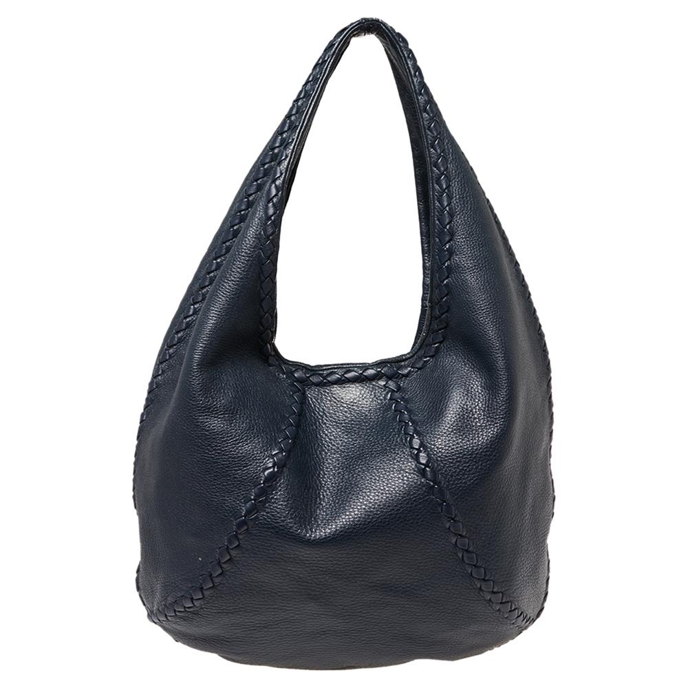 Crafted in Italy, this Bottega Veneta Baseball hobo is made of leather and comes in a striking shade of blue. It has a classic silhouette and features a single handle. The exterior is beautified with woven leather trims and the spacious interior is