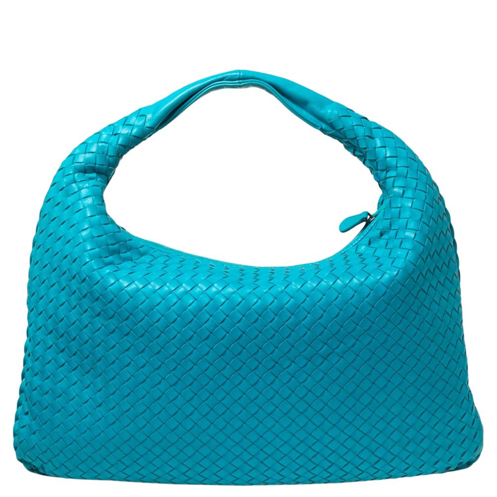 The excellent craftsmanship of this Bottega Veneta hobo ensures a brilliant finish and a rich appeal. Woven from leather in their signature Intrecciato pattern, the blue-hued bag is provided with minimal hardware. It features a loop handle and a top