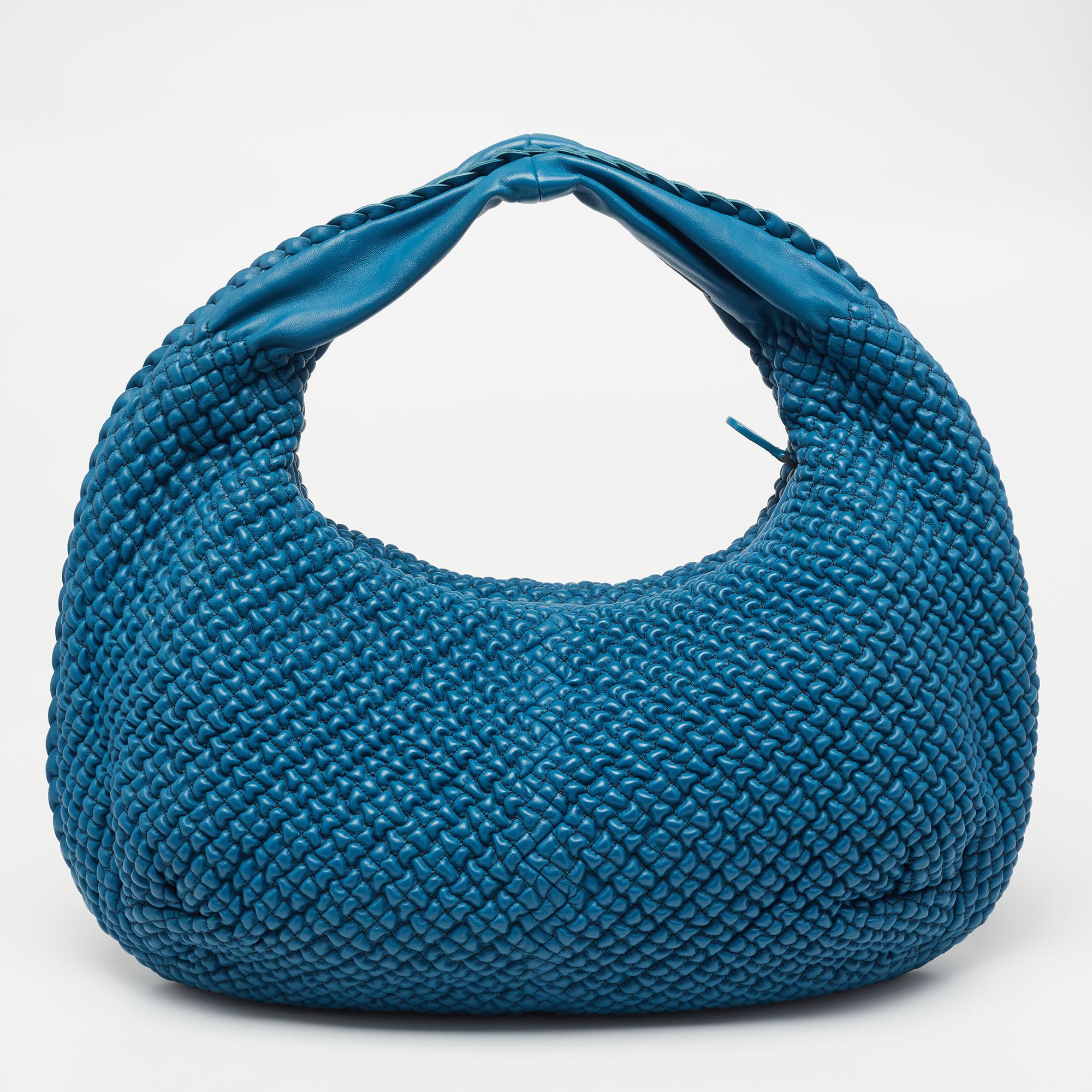 The excellent craftsmanship of this Bottega Veneta hobo ensures a brilliant finish and a rich appeal. Fashioned in bubble-quilted leather, the blue-hued bag is provided with minimal hardware. It features a comfortable handle and a top zip closure,