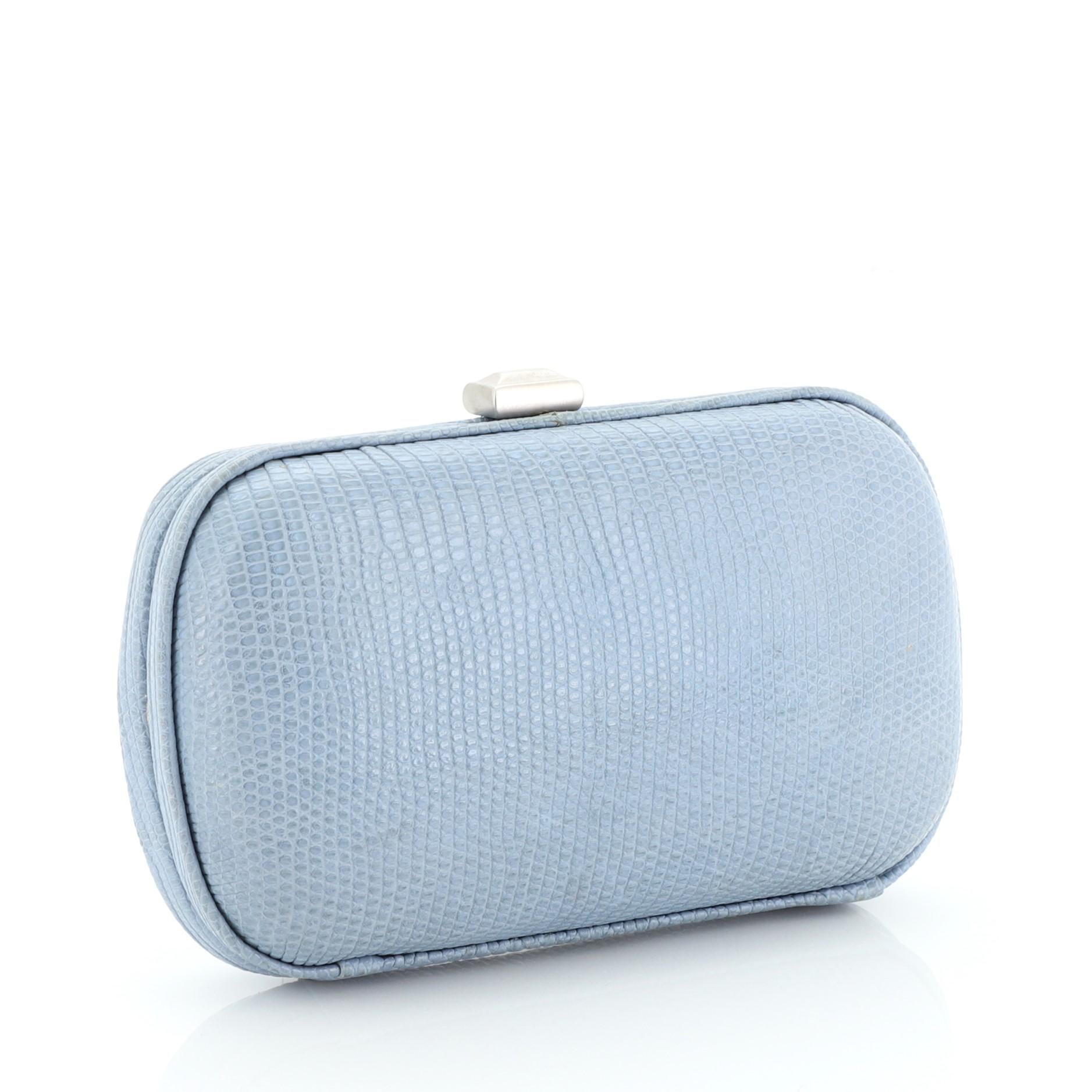 This Bottega Veneta Box Clutch Lizard Small, crafted from genuine blue lizard skin, features lizard skin frame trims and silver-tone hardware. Its press-lock closure opens to a gold fabric interior.

Condition: Fair. Glue stains along exterior edge,