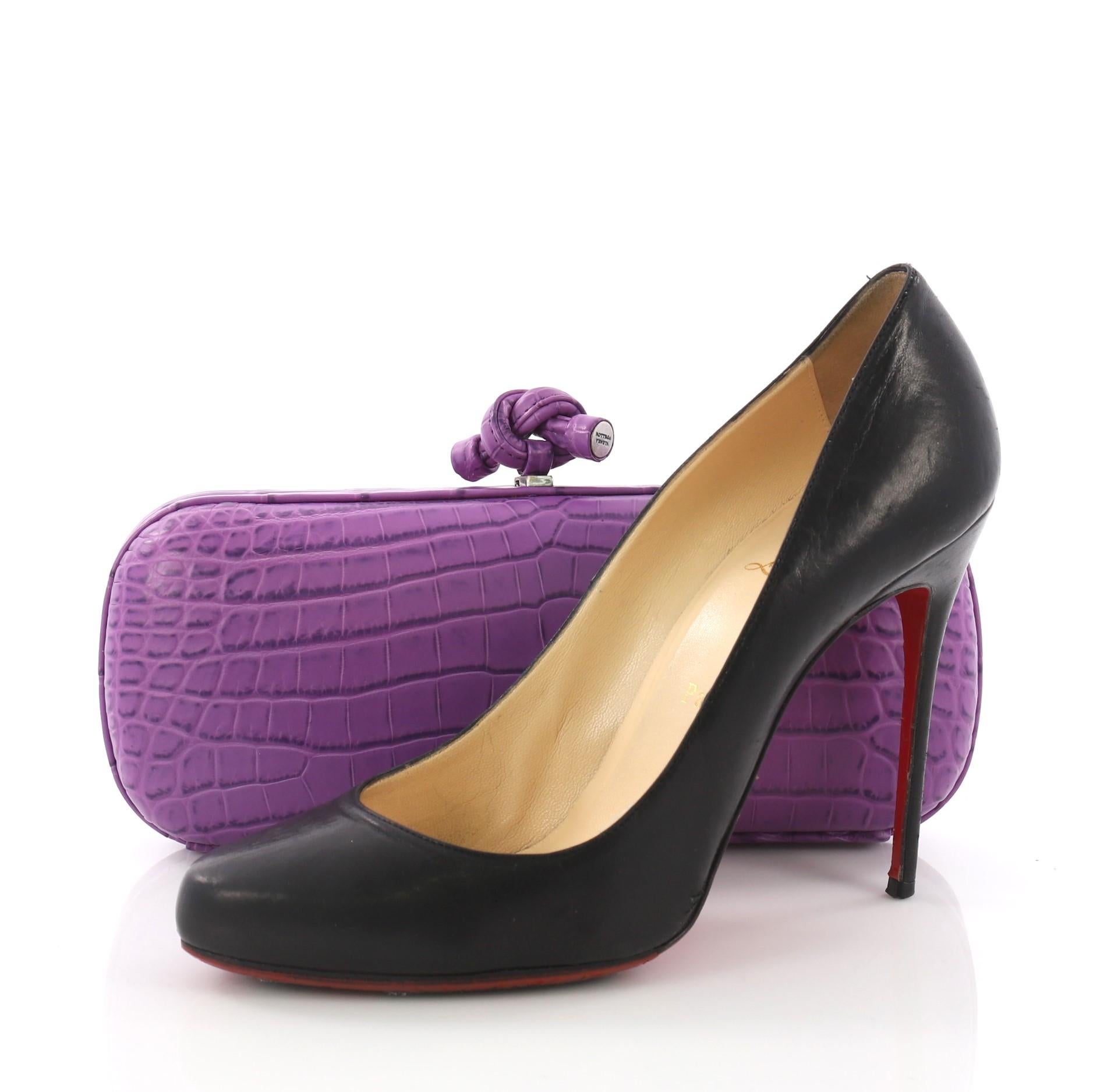 This Bottega Veneta Box Knot Clutch Crocodile Long, crafted from genuine purple crocodile skin, features silver-tone hardware . Its top knot clasp closure opens to a gray microfiber interior. **Note: Shoe photographed is used as a sizing reference,