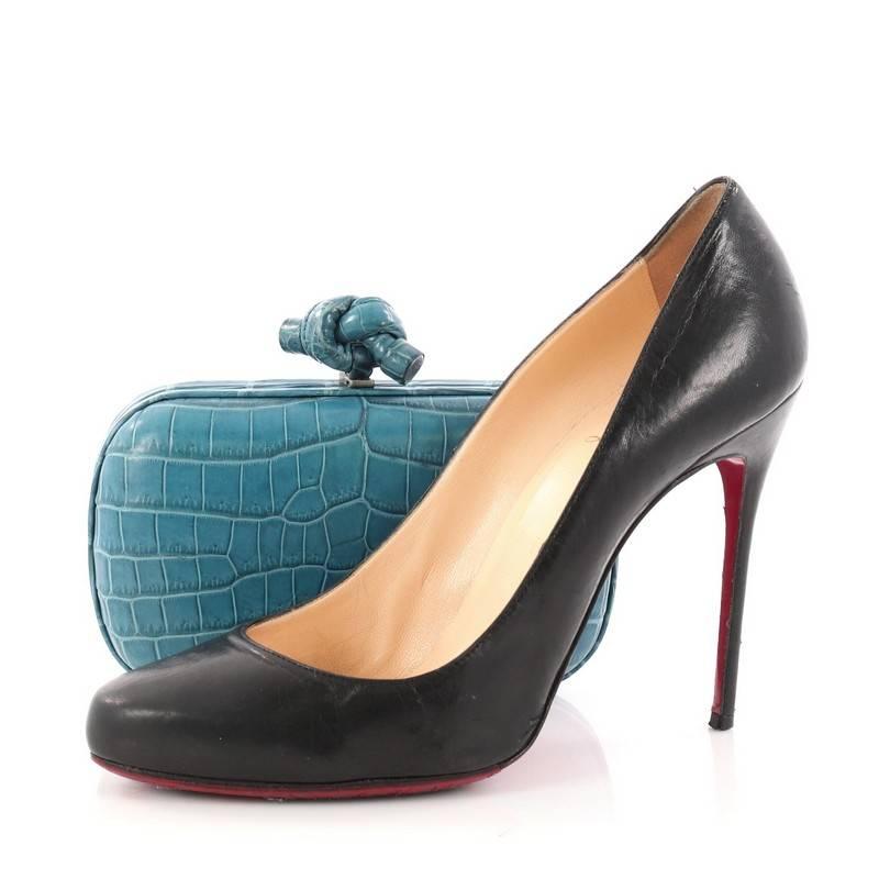 This authentic Bottega Veneta Box Knot Clutch Crocodile Small is a simple yet stunning accessory for any formal event. Crafted from genuine blue crocodile skin, this sleek, hard-shell clutch features crocodile frame trims and aged silver-tone