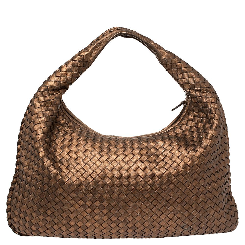 Luxuriously designed, this Veneta hobo from Bottega Veneta is splendid to look at and flaunt this season. It has been crafted from bronze leather in the brand's signature Intrecciato pattern and features a single top handle. It opens to a