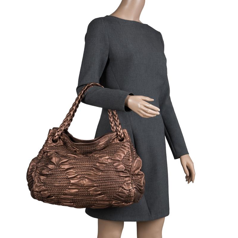One look at this hobo from Bottega Veneta and you'll know why it is a limited-edition piece. It is high in style and magnificent in appeal. Crafted from leather in a bronze hue and styled with two braided handles, it has suede interiors that are