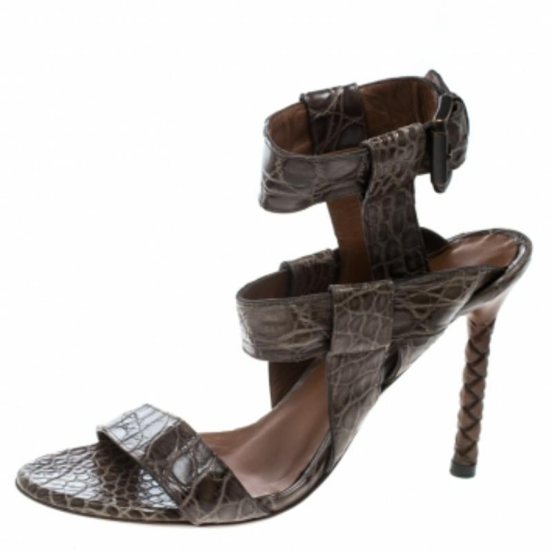 Finement confectionnées en cuir d'alligator dans un design à lanières, ces sandales Bottega Veneta sont prêtes à vous faire vivre une expérience haute couture. Ils présentent des orteils ouverts, des fermetures à boucle à la cheville et reposent sur