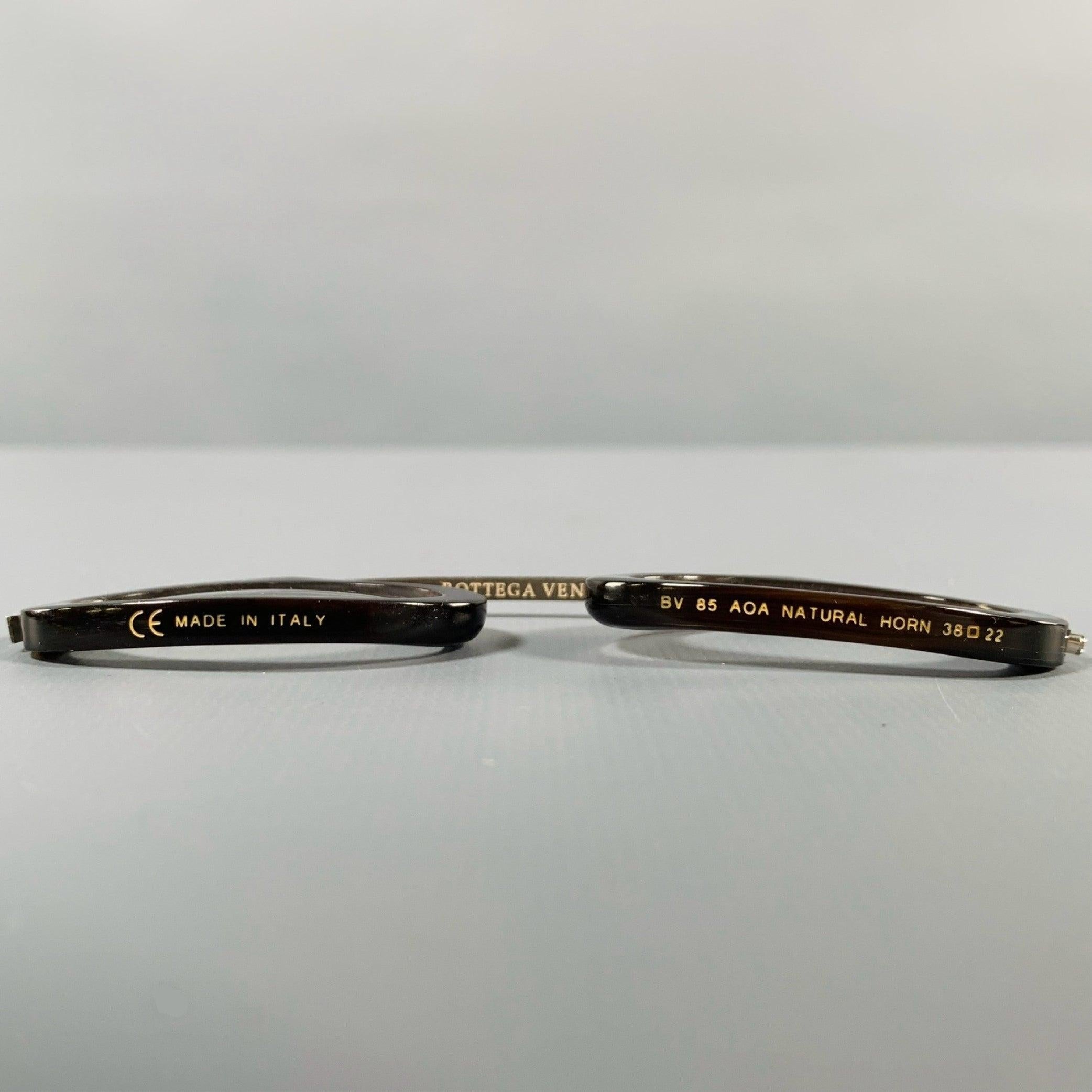 BOTTEGA VENETA monocle
eyewear in a brown horn featuring a monocle style, leather cord with pin, and untinted lenses. Comes with woven case, card of authenticity, and conditioner. Made in Italy. Note: lenses are RX and will need to be replaced.Very