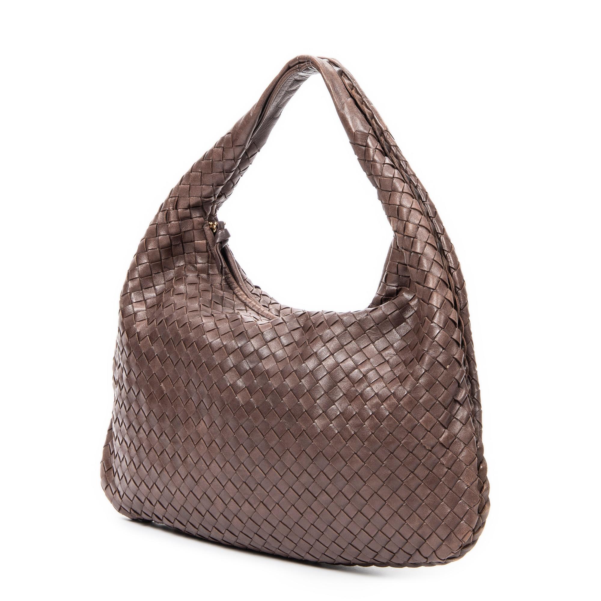 Elevate your sophistication with the Brown Classic Hobo, crafted in luxurious brown intrecciato leather. Gold hardware complements the suede interior that unveils a zippered pocket. This creation showcases Bottega Veneta's mastery in combining