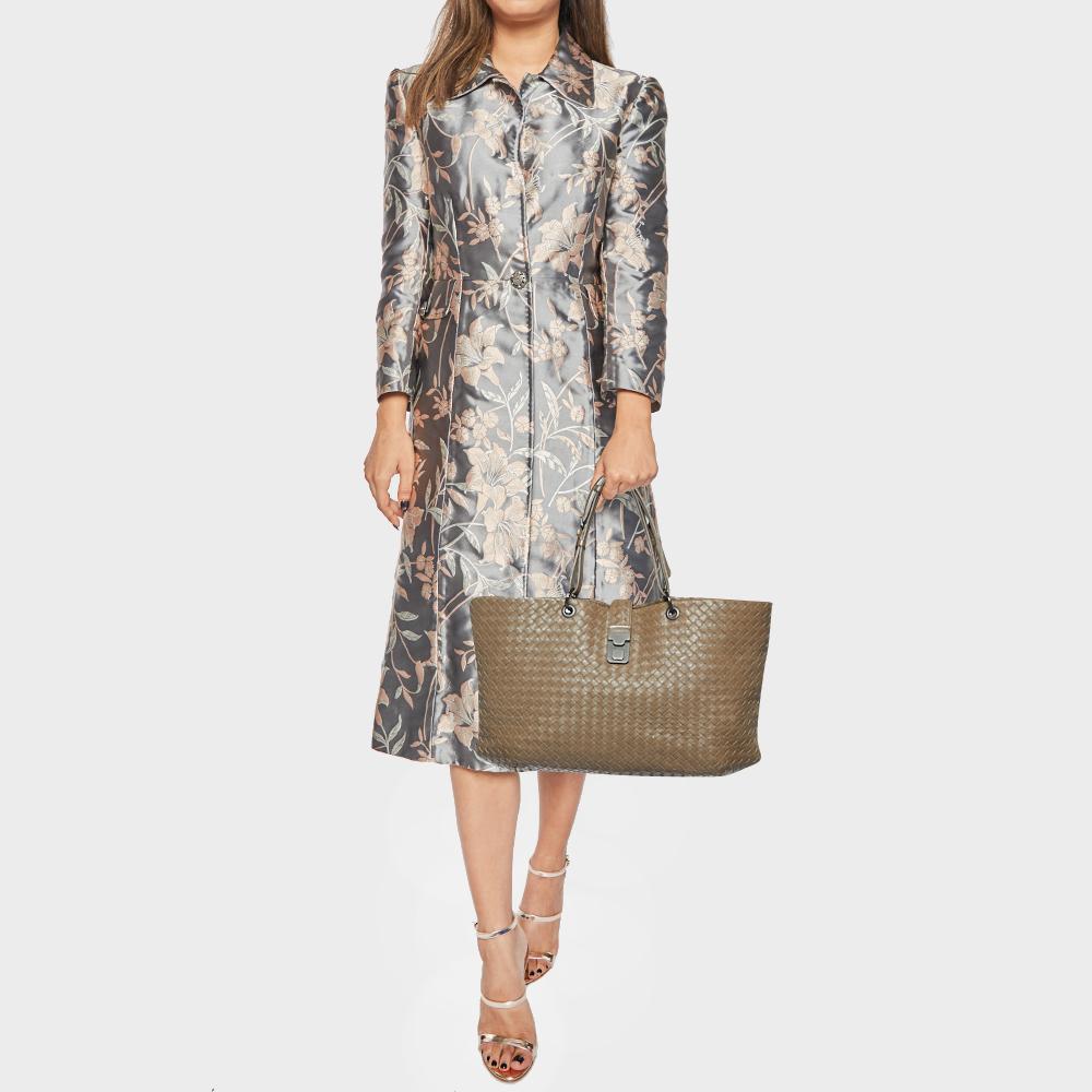 This luxurious Capri tote from Bottega Veneta is ideal for everyday use. Crafted from black leather it features adjustable top handles and a woven pattern all over. The buckled closure opens to a suede lined roomy interior that can hold your daily
