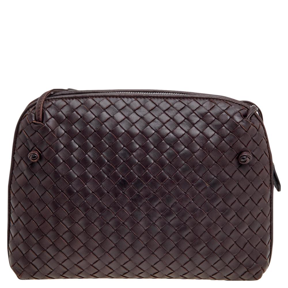 This Nodini crossbody bag from the House of Bottega Veneta will fetch nothing but complete practicality and style. It is made from brown Intrecciato leather on the exterior and flaunts a sturdy, structured shape. It has silver-toned hardware and a