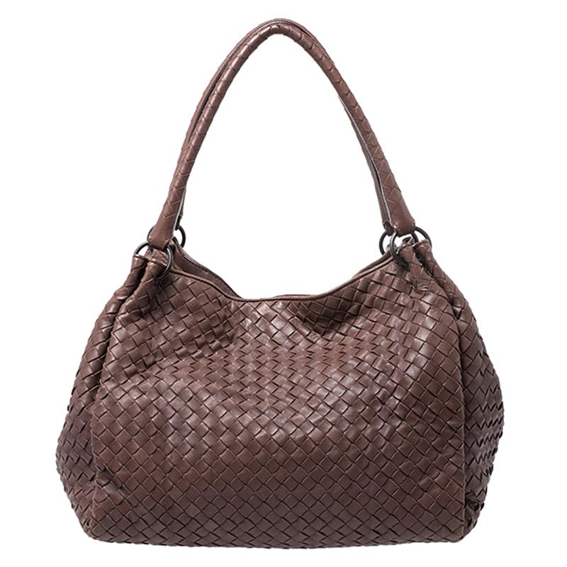 Showcasing a refreshing design, this Bottega Veneta handbag ideally complements your look. Crafted in Italy, it is made of brown leather and features the brand's iconic Intrecciato weave throughout. This Parachute bag is held with dual handles, has