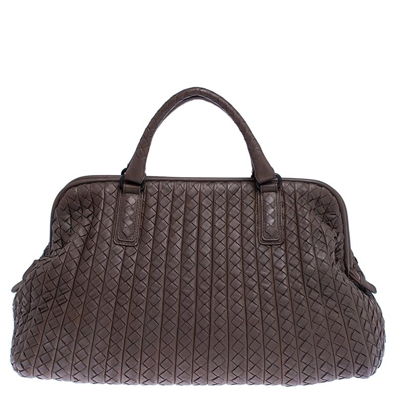 Amp up your handbag collection by getting yourself this bag by Bottega Veneta. This lovely brown bag is crafted from leather in the signature Intrecciato pattern and features dual handles. Its top zip closure opens to a suede lined interior and it