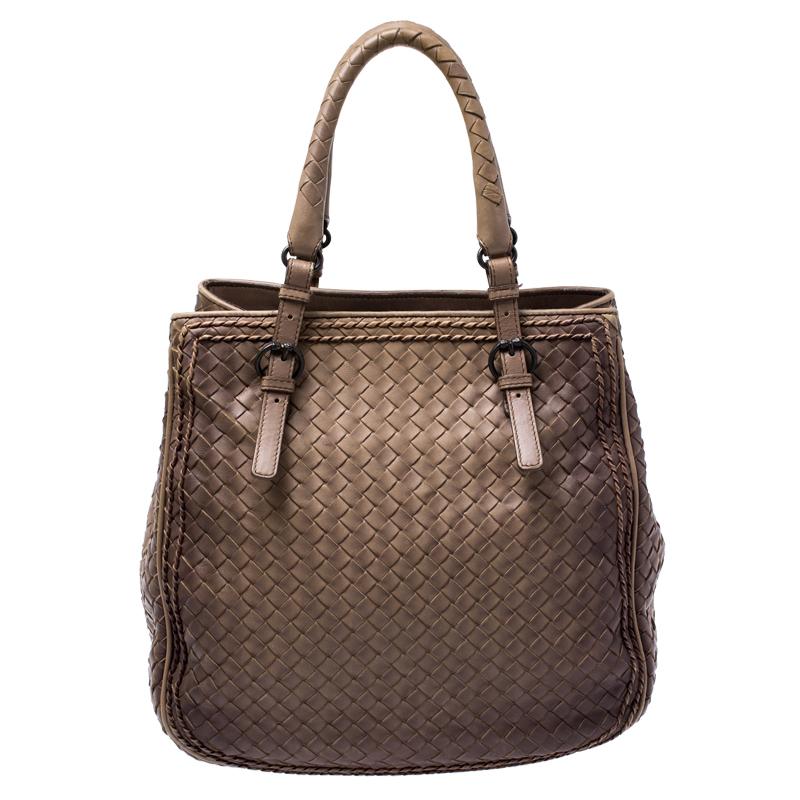 This bag from Bottega Veneta is crafted from brown leather using their signature Intrecciato weaving technique and flaunts a seamless design. This satchel, personifying elegance and subtle charm, is held by two handles. Brimming with artistry and