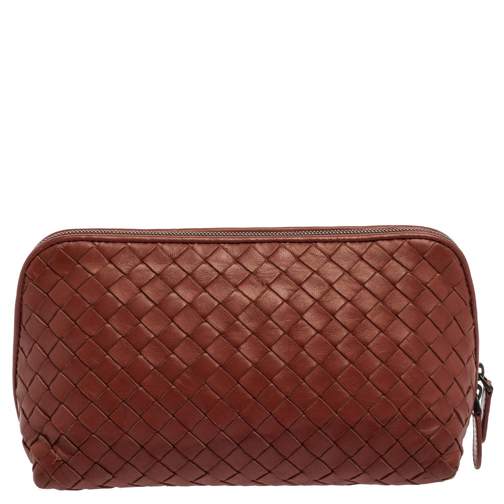 This women's clutch from Bottega Veneta has been made in Italy by weaving leather in the Intrecciato pattern. It has a fabric-lined interior that is secured by a top zip closure. This brown clutch has a simple design and a timeless quality.

