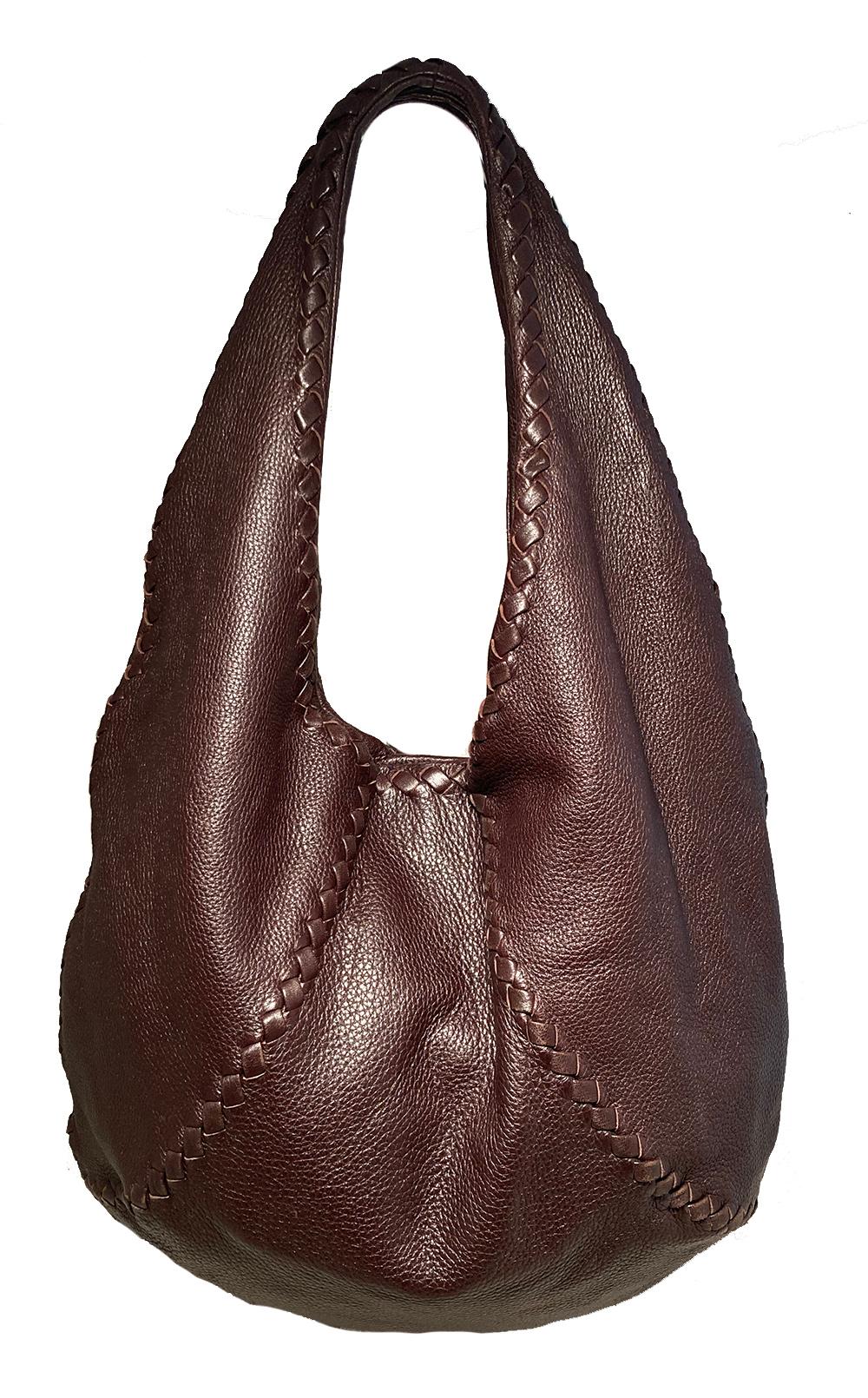Bolso Hobo de cuero marrón de Bottega Veneta en muy buen estado. Exterior de suave piel marrón en estilo hobo único con bordes de piel trenzada similares a las costuras tejidas de una pelota de béisbol. Cierre superior magnético. Interior de ante