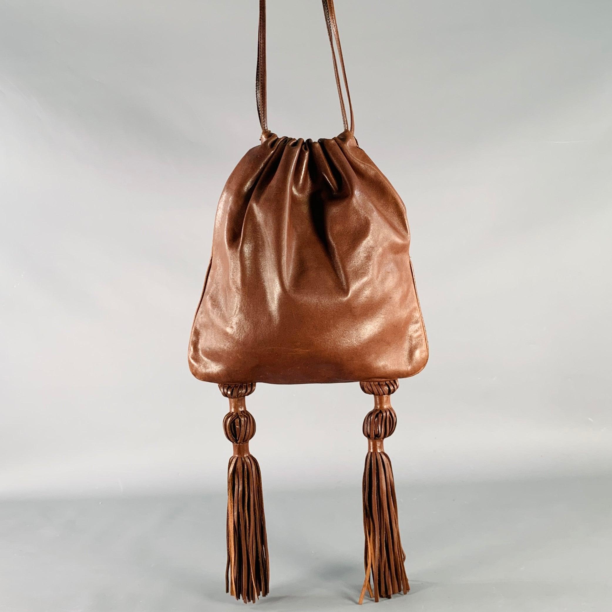 Sac à bandoulière BOTTEGA VENETA
en cuir marron, avec des détails en forme de houppes et un cordon de serrage. Livré avec un sac à poussière. Fabriqué en Italie. Très bon état. Signes mineurs d'usure. 

Mesures : 
  Longueur : 10 pouces Hauteur :