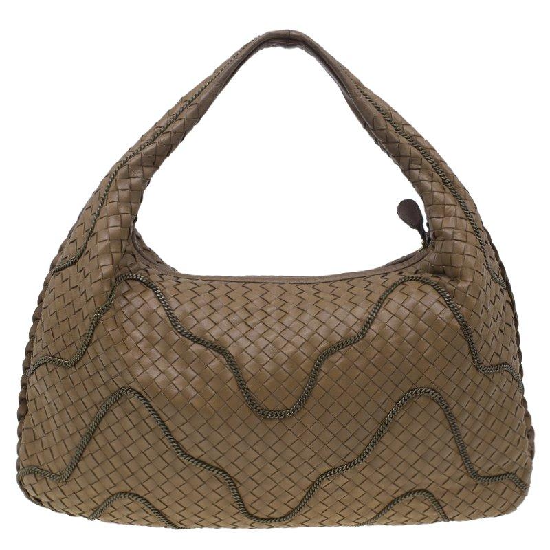 Be on the path of timeless luxury with this Bottega Veneta Leather Chain hobo. Crafted from the signature intrecciato woven nappa leather, the brown exterior features wavy chain embroidery in antique brass and a top zip closure. The interior is