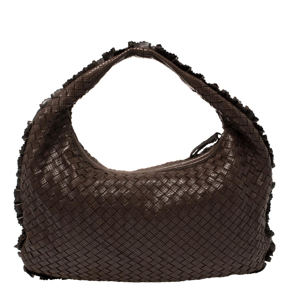 Luxuriously designed, this Veneta hobo from Bottega Veneta is splendid to look at and flaunt this season. It has been crafted from brown perforated leather in the brand's signature Intrecciato pattern and features a single top handle. It opens to a