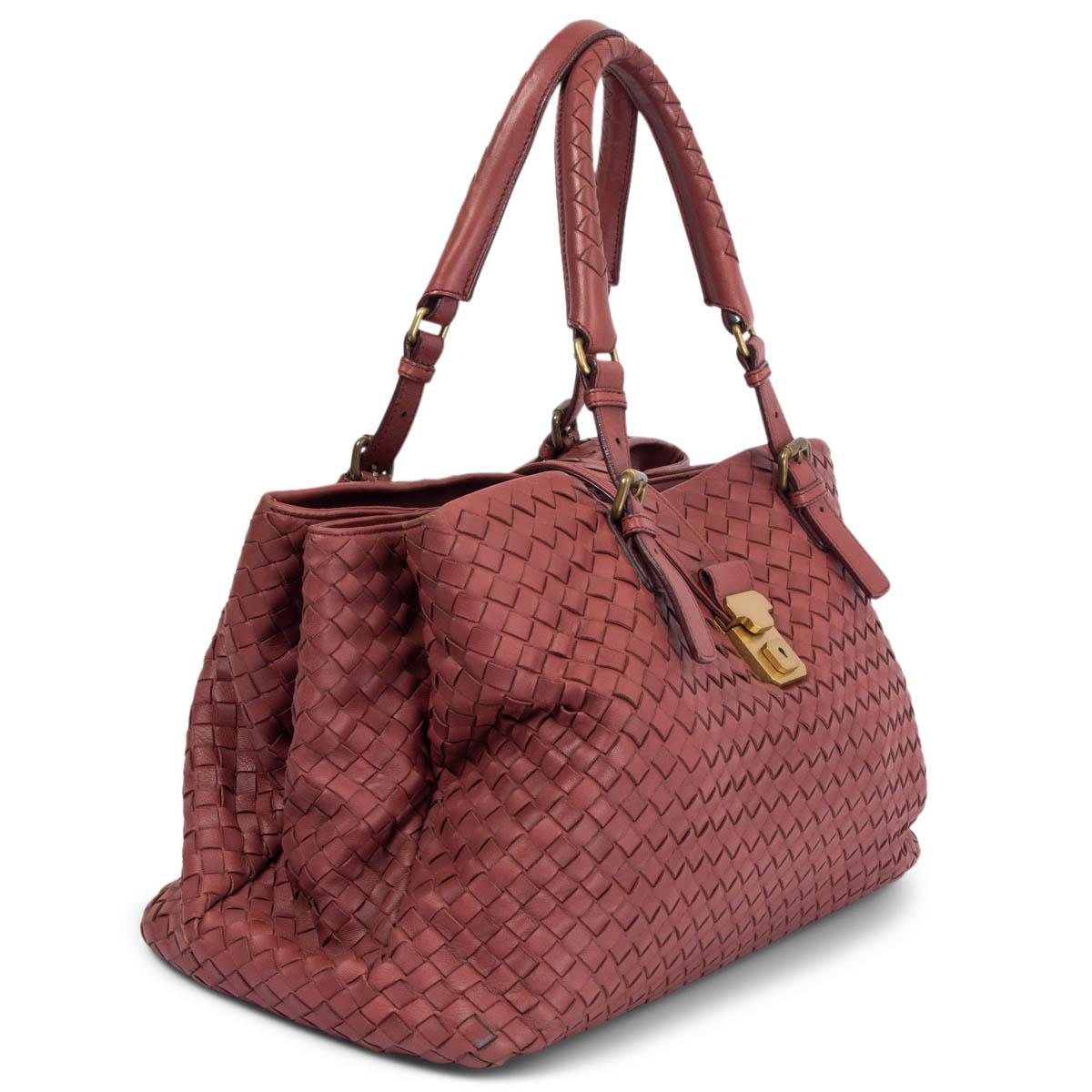 100% authentic Bottega Veneta Medium Roma Tote Bag in burgundy signature Intrecciato nappa leather. Featuring round top handles and a fold-over top with gold-tone push-lock closure. Interior is divided in three compartments. Lined in pale coral