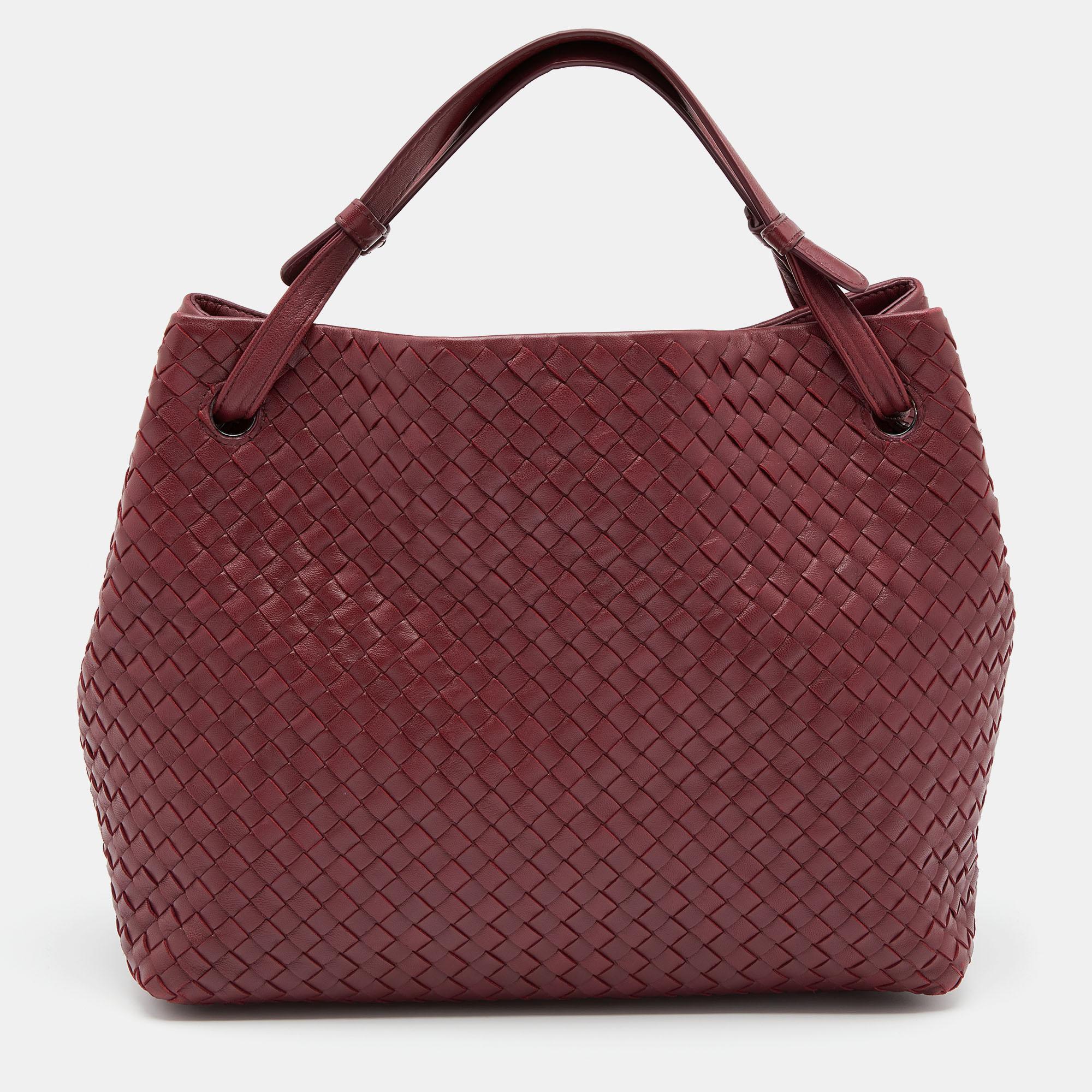This Bottega Veneta bag presents the label's artistry in fine craftsmanship and classic designs. Sewn using Intrecciato leather, it features a burgundy shade, short handles, and a well-sized interior for your essentials.

Includes: Original Dustbag,