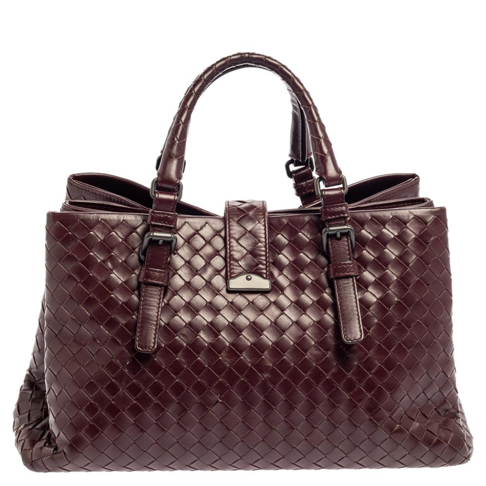 This Bottega Veneta tote is a creation that brings joy to one's sight! It has been beautifully crafted from leather and designed in their signature Intrecciato pattern while being held by two top handles. The bag is also equipped with a flap
