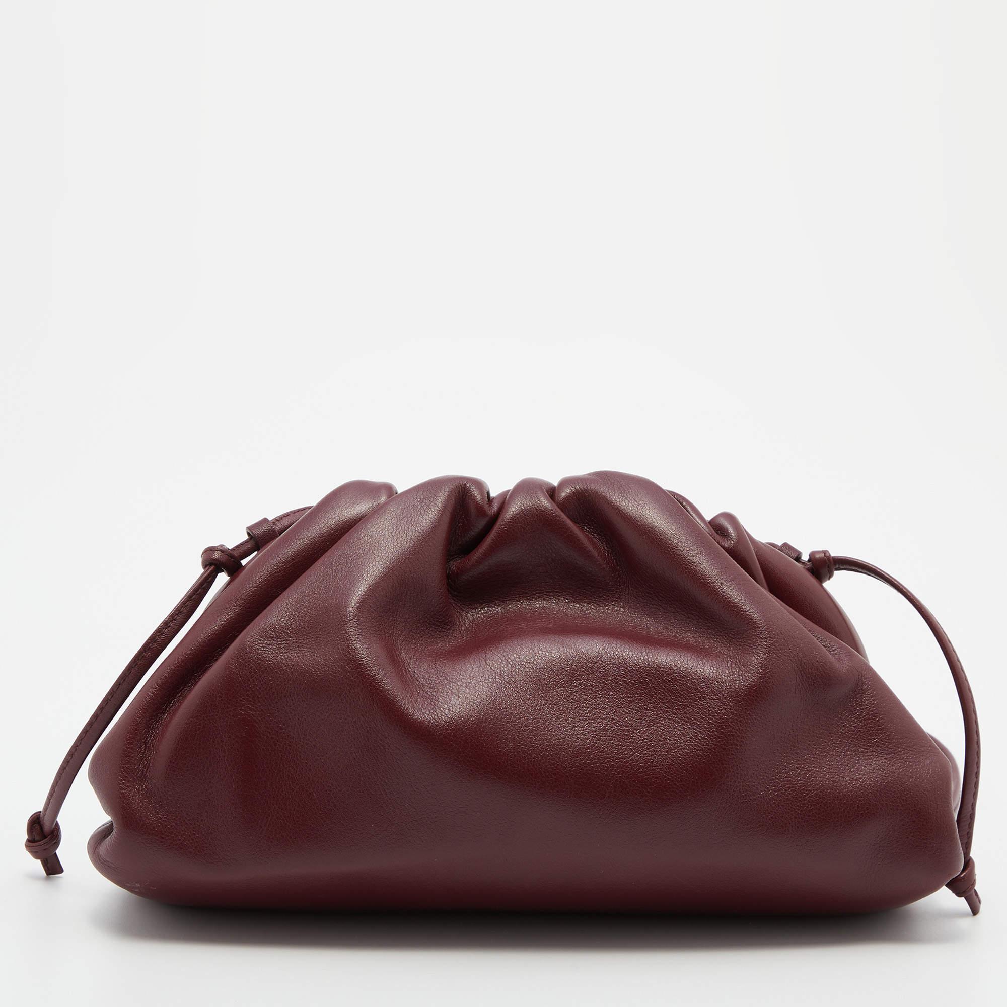 In line with Bottega Veneta's DNA, Daniel Lee vouched for clean lines and a timeless appeal during his stint as Creative Director. This mini The Pouch bag is made from burgundy leather and gathered along the top. It can be held in your hand, tucked