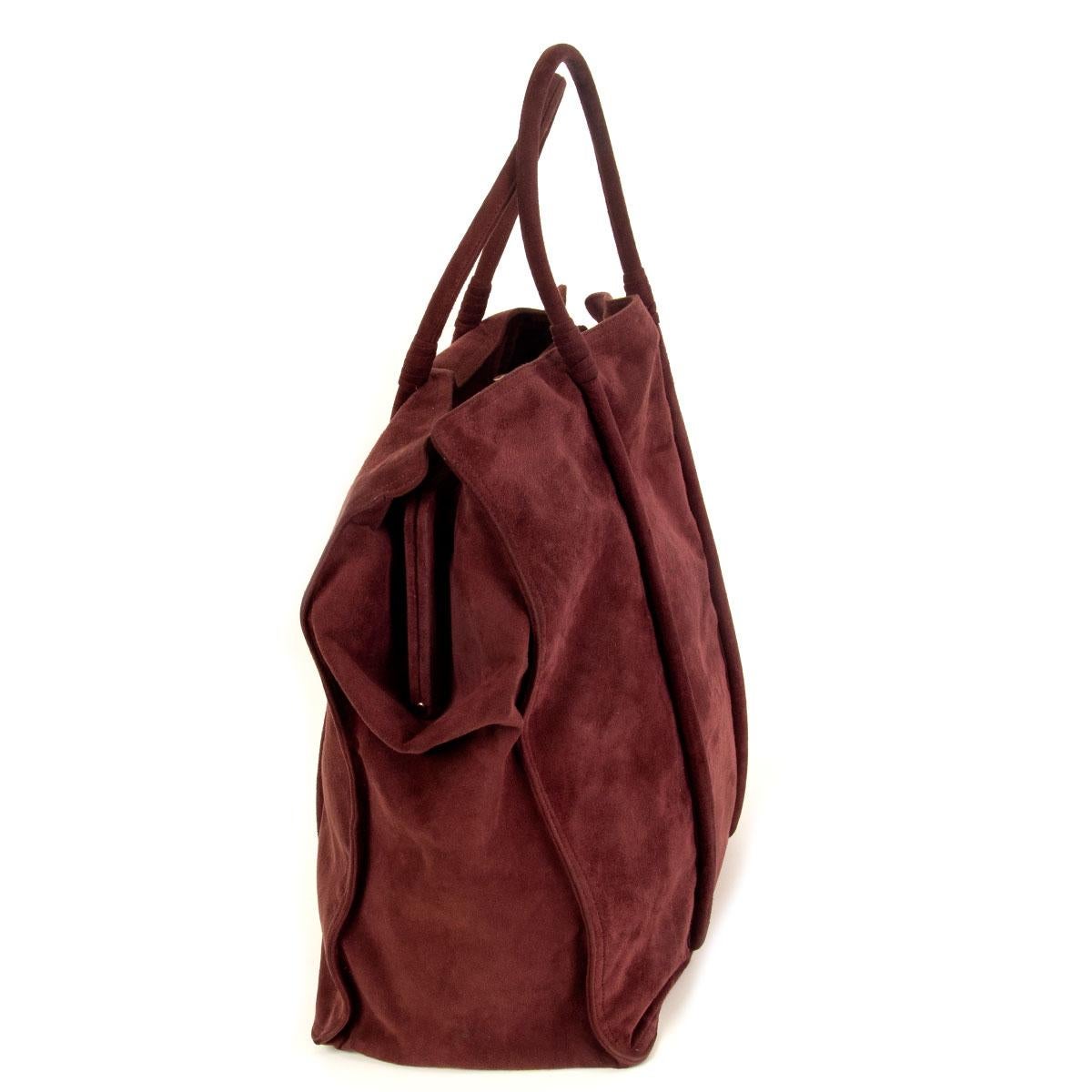 100% authentic Bottega Veneta tote bag in burgundy suede. Interior is divided in three compartments and the middle one opens with a gold-tone metal closure and has one big zip pocket on the inside. Bag is lined in canvas and smooth lambskin. Has