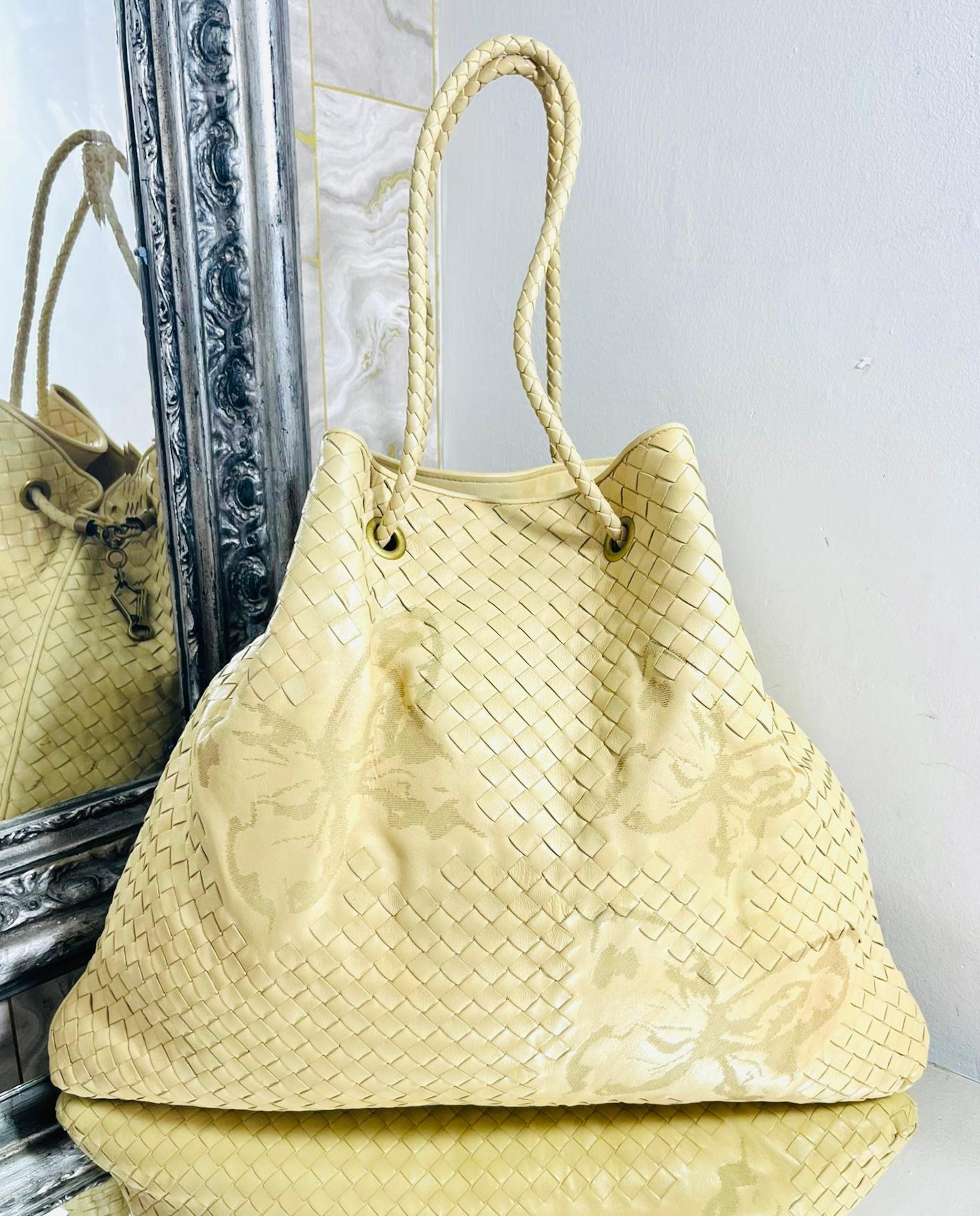 Bottega Veneta Butterfly Embossed Woven Leather Bag

Beige, trapezium shaped tote bag embellished with butterfly embossed motif.

Detailed with aged gold hardware, attached key ring and woven dual handles.

Featuring blue suede interior with slit