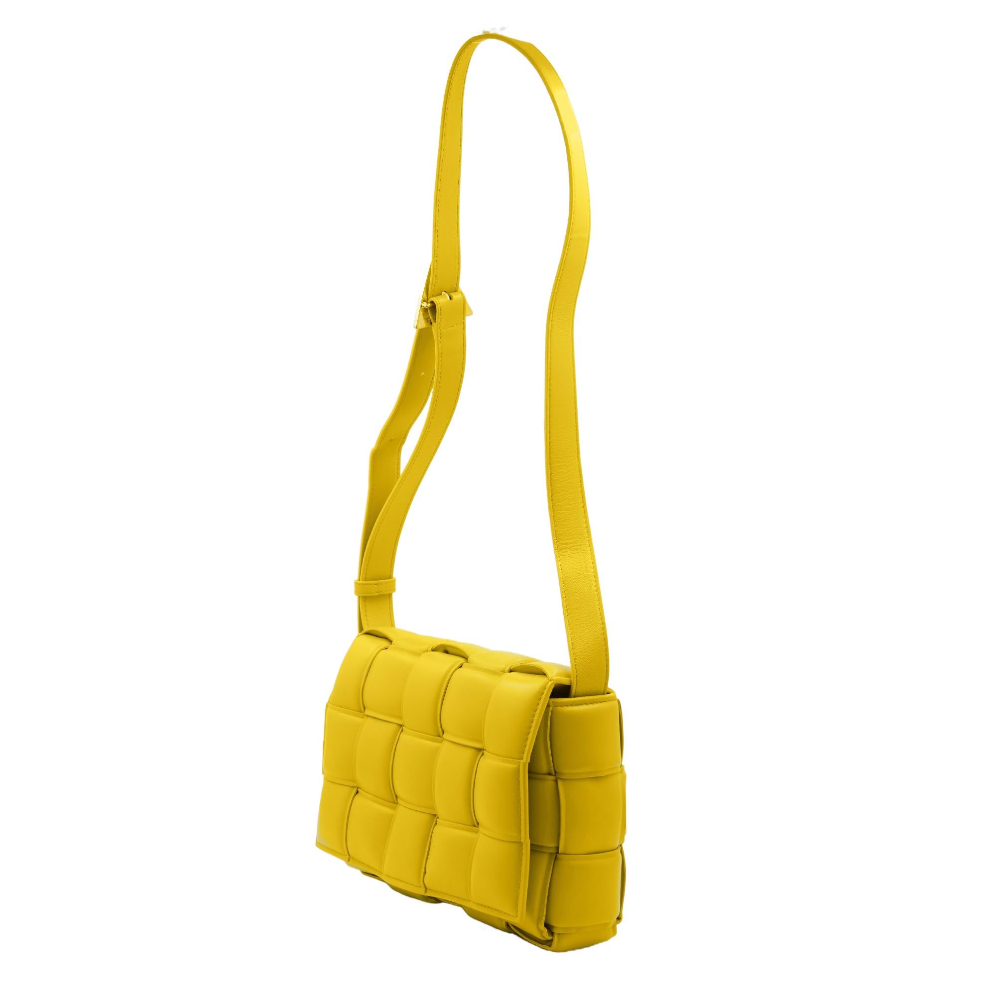 The famous Bottega Veneta Cassette Padded lambskin yellow leather crossbody bag. Adjustable shoulder strap with gold-colored metal buckle closure. Front flap with magnetic snap button closure. One internal zip pocket. Made in Italy. Measurements: D
