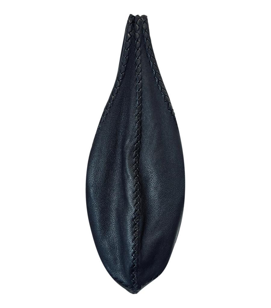 Bottega Veneta Cervo Leather Hobo Bag
Black shoulder bag crafted from deerskin and designed with signature Intrecciato weave trims.
Featuring snap centre fastening leading to spacious suede interior with zipped pocket.
Size – Height 36cm, Width