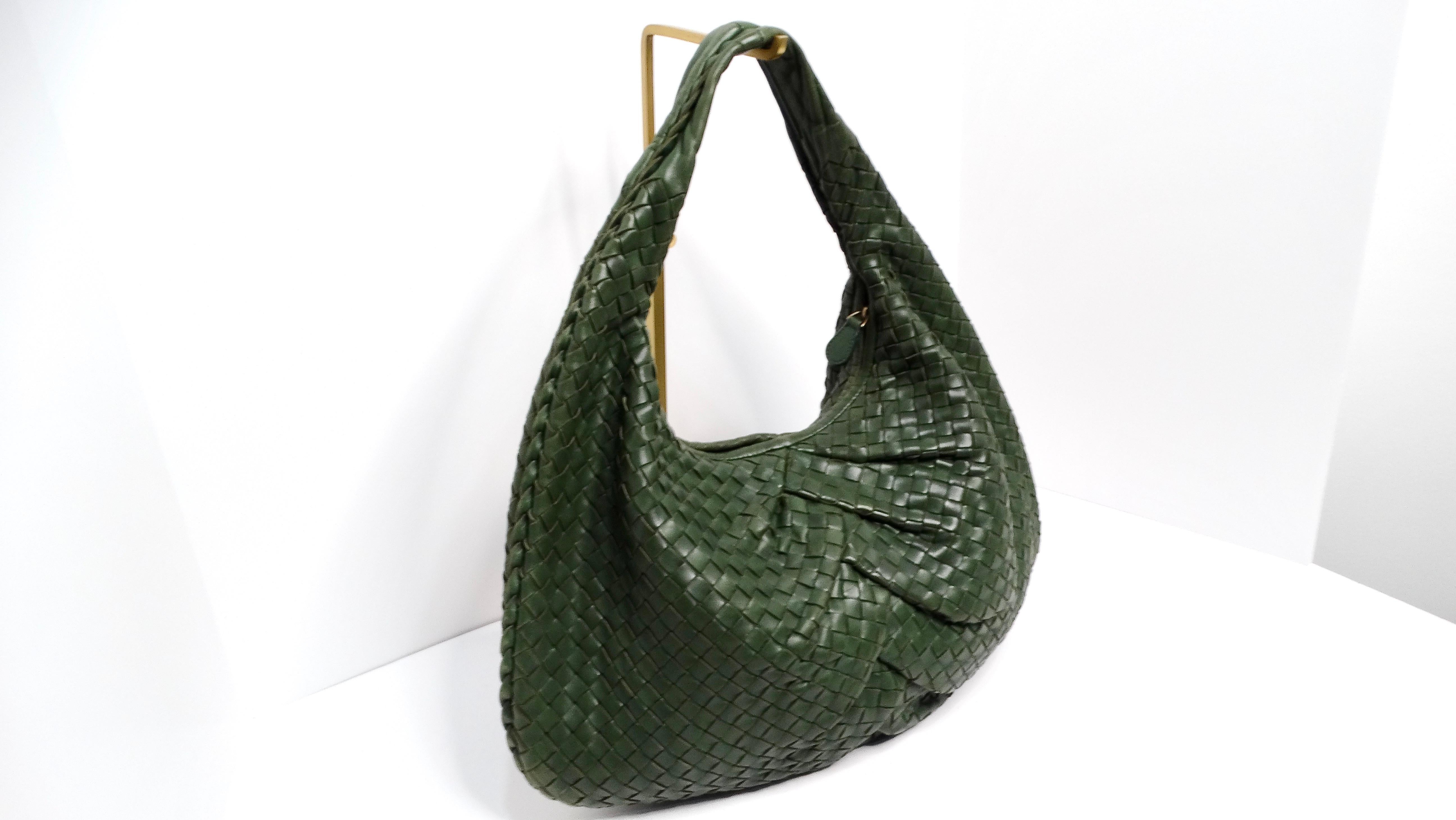 The Bottega Veneta Circa 1990s Green Intrecciato Leather Woven Hobo Bag is a classic example of the brand's iconic craftsmanship and timeless appeal. This spacious bag features a rich, dark olive green hue that lends itself to versatility, making it