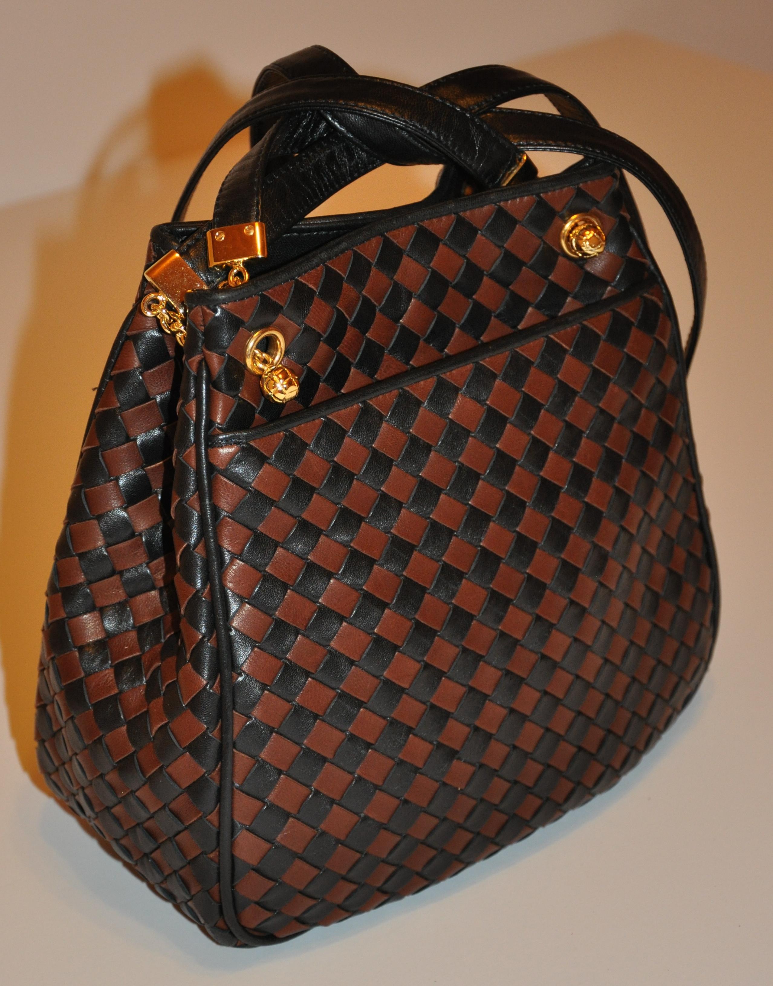        Bottega Veneta wonderfully detailed Coco-brown & black signature woven lambskin double-strap shoulder bag is accented with lambskin piping throughout. The exterior of the bag has a open compartment for optional use. Bag is highlighted with