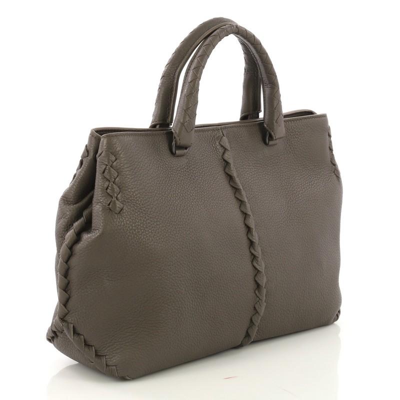 This Bottega Veneta Convertible Tote Leather with Intrecciato Detail Medium, crafted from taupe leather with intrecciato detail, features dual leather handles and gunmetal-tone hardware. Its magnetic closure opens to a taupe suede interior with zip