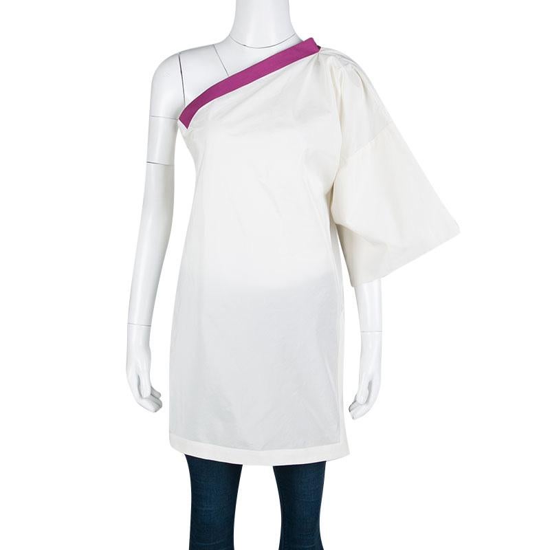Cut to a stylish silhouette with one shoulder design; this Bottega Veneta tunic top is perfect for your casual dos. It flaunts a cream hue with contrasting purple trims. Crafted from a blend of cotton and silk, the top will work best with regular