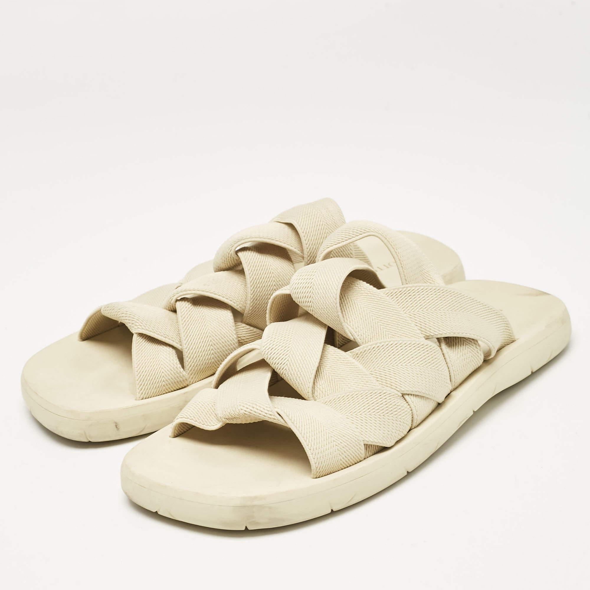Frame your feet with these Bottega Veneta flat sandals for men. Created using cream colored fabric  they have loosely woven uppers and durable rubber soles.