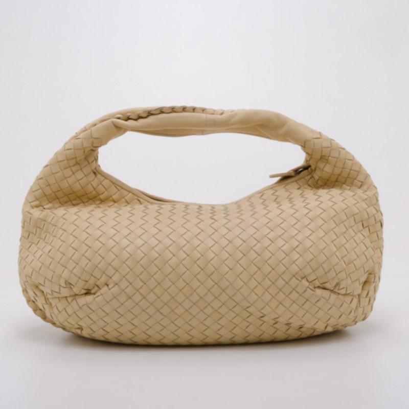From the luxurious Italian brand that is known for their extremely well crafted leather goods, this classic Bottega Veneta hobo is no exception. It's hand crafted from beige woven leather that features a single shoulder strap and top zip closure.