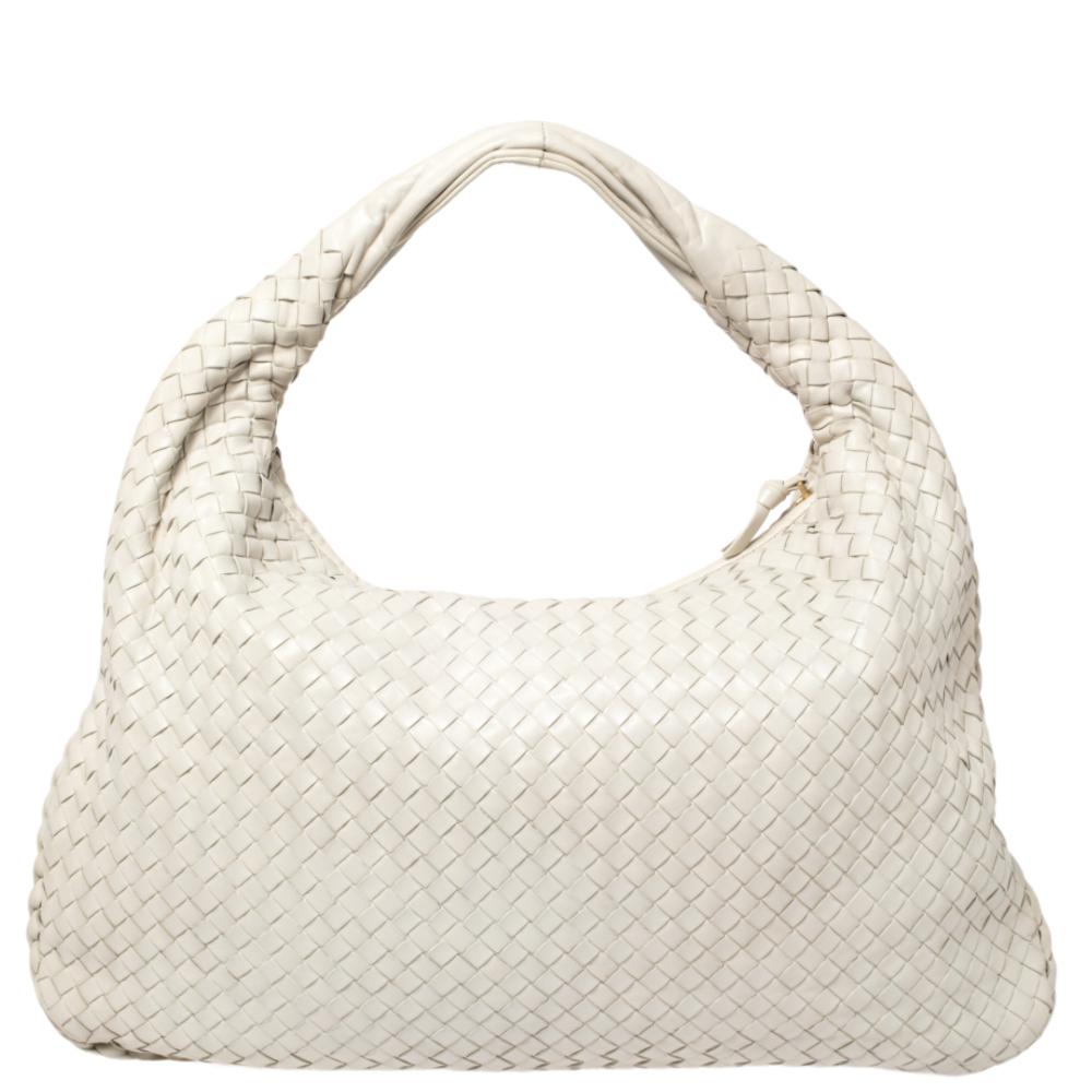 The excellent craftsmanship of this Bottega Veneta hobo ensures a brilliant finish and a rich appeal. Woven from leather in their signature Intrecciato pattern, the cream-hued bag is provided with minimal gold-tone hardware. It features a single