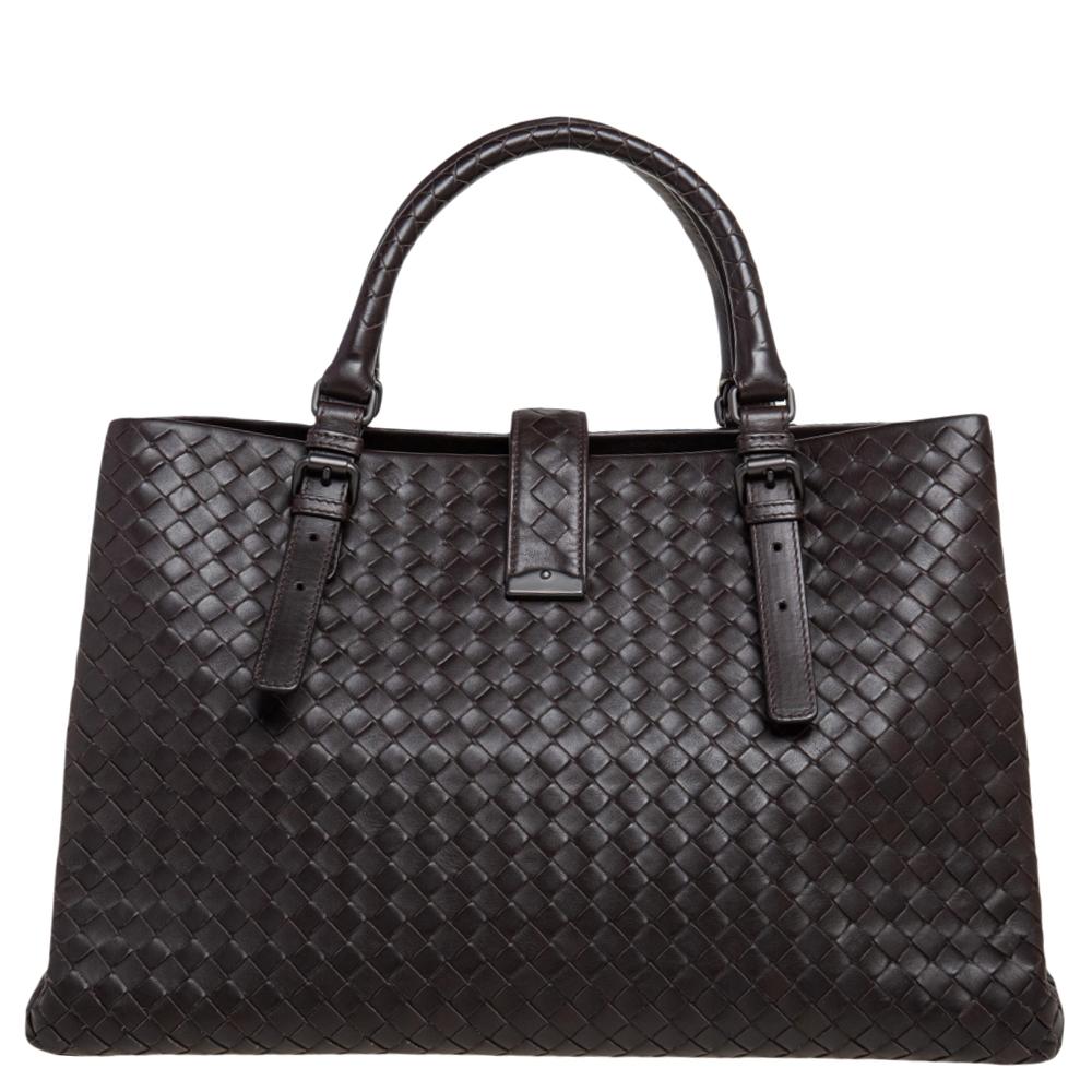 Bottega Veneta's Roma tote is a timeless addition to your accessory edit. The bag is skillfully woven, employing their signature Intrecciato technique that strengthens the leather. This dark brown-hued creation opens to capacious suede compartments.