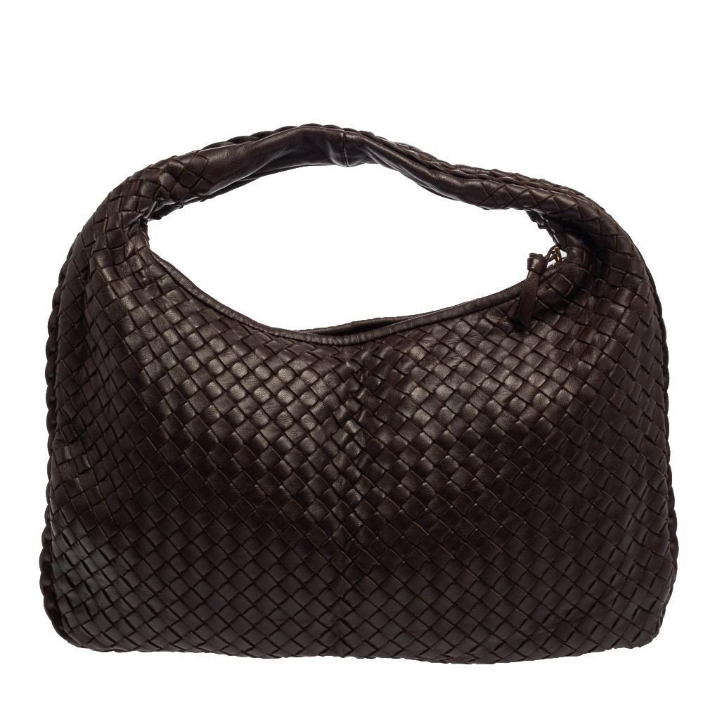 The excellent craftsmanship of this Bottega Veneta handbag ensures a brilliant finish and a rich appeal. Woven from leather in their signature Intrecciato pattern, the dark brown bag is provided with minimal gold-tone hardware. It features a loop