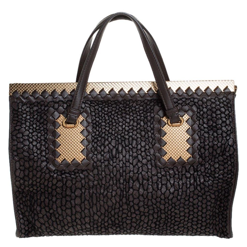 This beautiful bag from Bottega Veneta makes for a perfect everyday accessory. Crafted from leather, the bag features an interesting design all over in a dark brown shade. It is equipped with dual top handles and a suede compartment perfectly sized