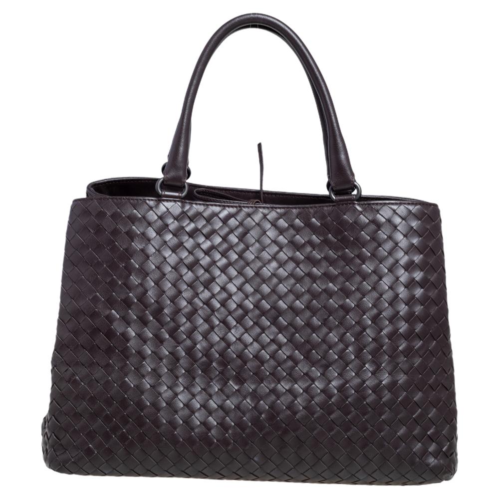 This beautiful dark brown tote from Bottega Veneta is spacious. Crafted from leather, it features double top handles and an interior lined with suede. The exterior of the bag carries the famous Intrecciato pattern that is unique to the fashion