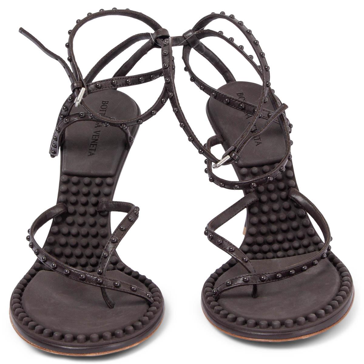 100% authentic Bottega Veneta Lagoon Bubble tonal lacquered stud sandals are crafted from dark brown nappa leather and embellished with tonal studs. The design features adjustable ankle straps, a shiny lacquered heel, and a rubber interior with