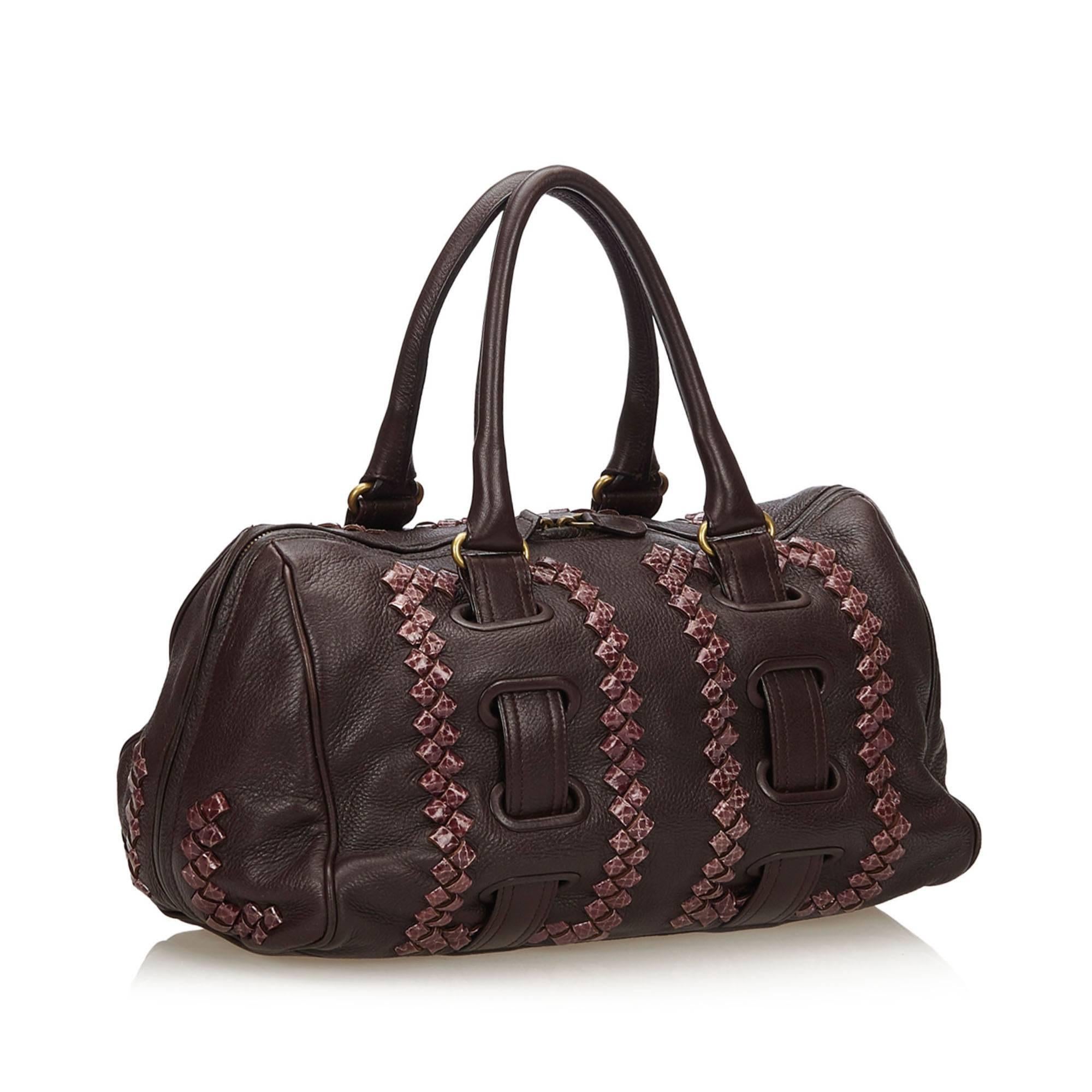 This boston bag features a leather body, rolled leather handles, top zip closure, and interior zip pocket. 

It carries a B condition rating.

Dimensions: 
Length 20 cm
Width 37 cm
Depth 14 cm
Shoulder Drop 20 cm

Inclusions: No longer comes with