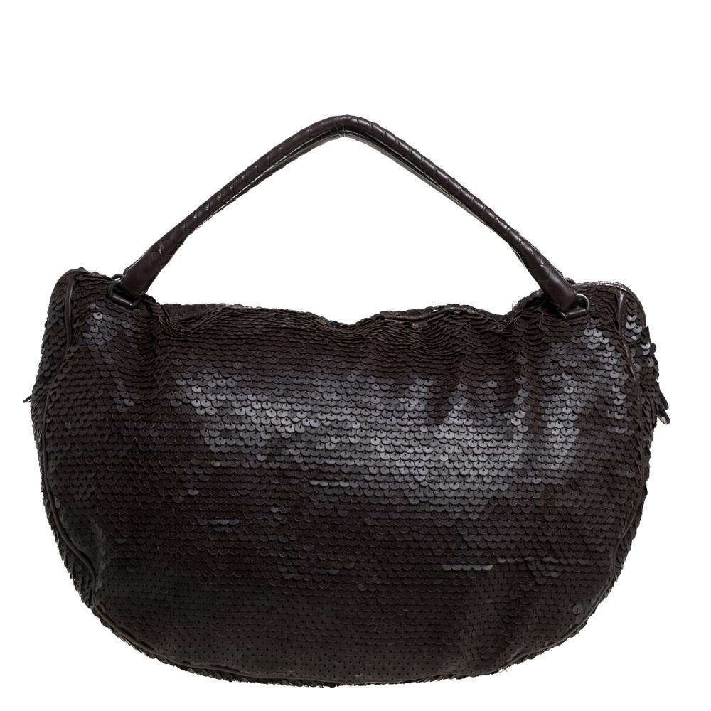 We are swooning over this beautiful Ebano Paillette hobo. Crafted from dark brown leather, the exterior of the bag is covered in sequins. The spacious interior of the bag is lined with suede and the hobo is held by two handles. This creation from