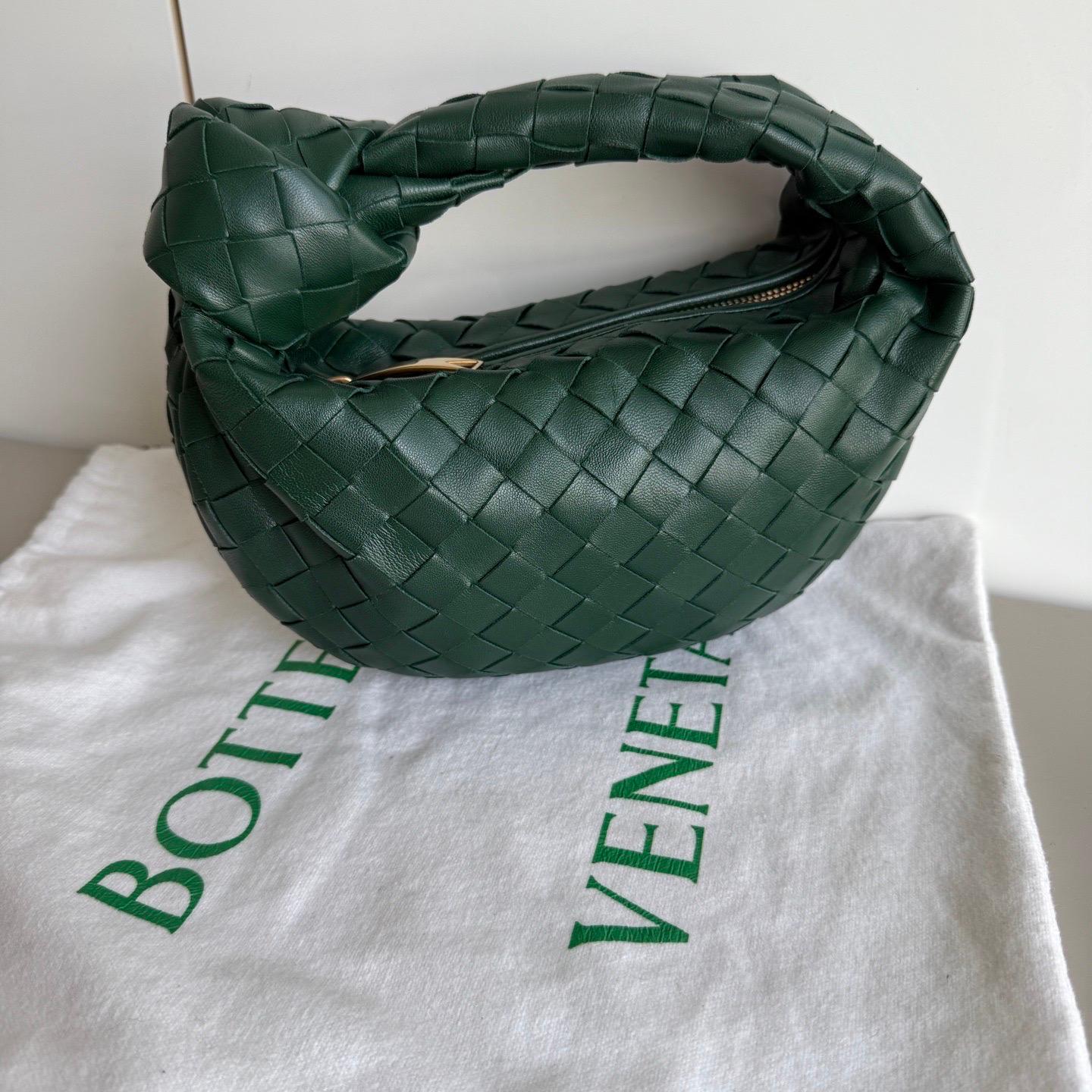Bottega Veneta Jodie Mini Dark forest green Lambskin Leather Clutch Bag
 These are professional photos of the actual bag.
 The Bottega Veneta Jodie Mini in elegant burgundy Leather offers the perfect balance between practicality and luxury. Its mini