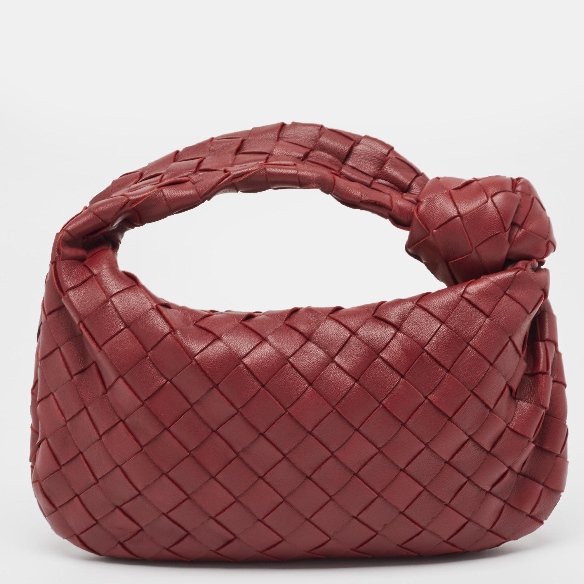 This Bottega Veneta Jodie bag is crafted from leather using their signature Intrecciato weaving technique into a seamless silhouette. This mini bag, personifying elegance and subtle charm, is held by a knotted handle. The bag has an interior sized