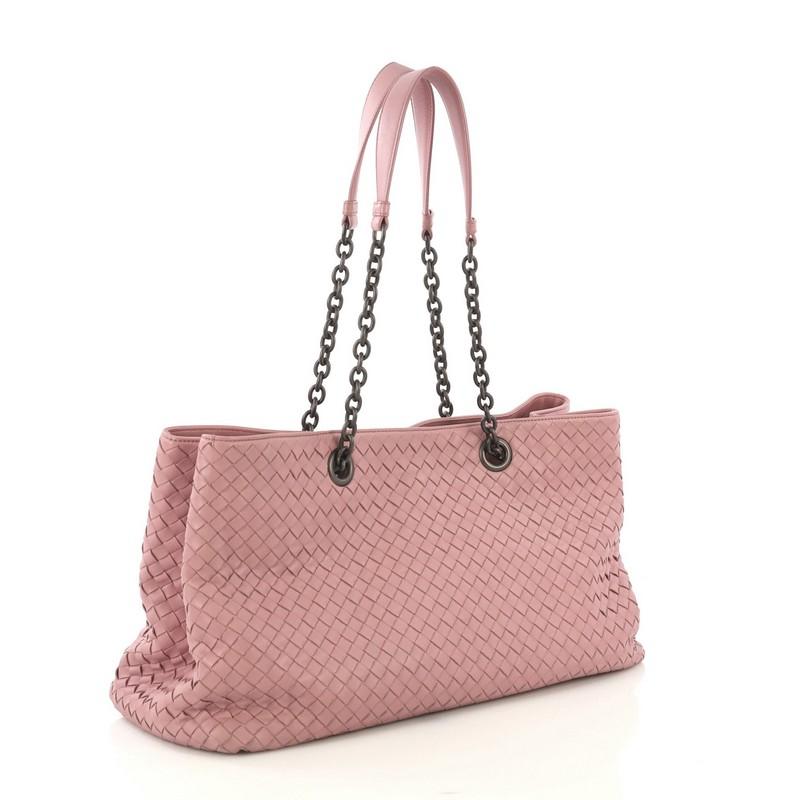 This Bottega Veneta Double Chain Tote Intrecciato Nappa Large, crafted from mauve intrecciato nappa leather, features dual chain link handles with leather pads and matte gunmetal-tone hardware. Its magnetic snap closure opens to a taupe suede