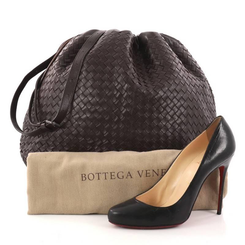 This authentic Bottega Veneta Drawstring Shoulder Bag Intrecciato Nappa Large, constructed from dark brown woven nappa leather, features a flat leather shoulder strap and brunito-finished gunmetal tone hardware accents. The bag's drawstring closure