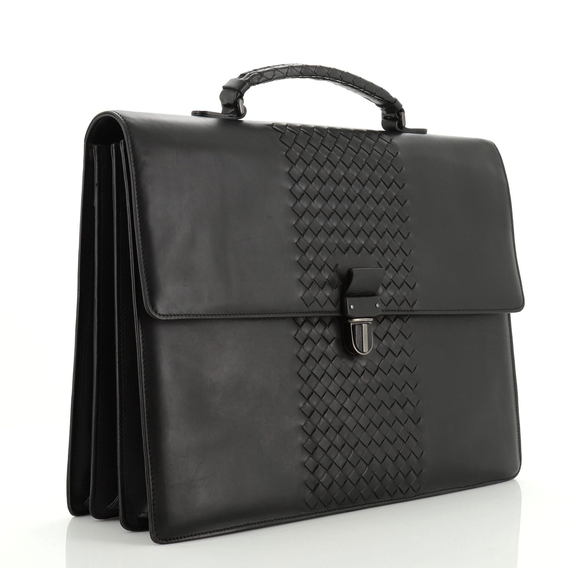 This Bottega Veneta Envelope Briefcase Leather with Intrecciato Detail, crafted in black leather with intrecciato detail, features a single loop handle, back zip pocket, and matte gunmetal-tone hardware. Its slide-lock closure opens to a black