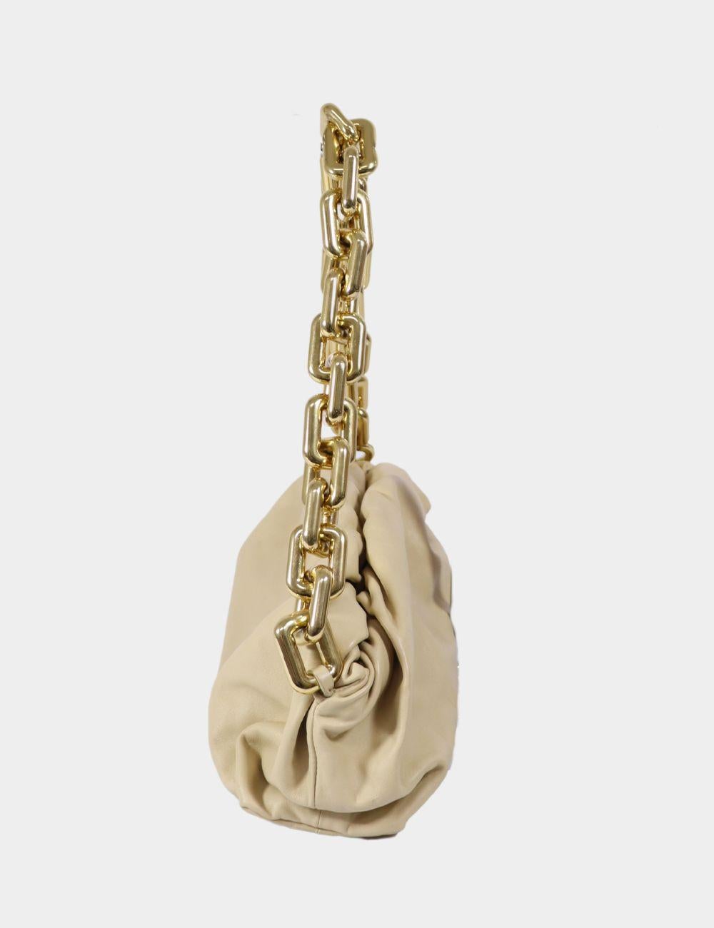 Bottega Veneta Pouch Bag with Gold Chain – Beige Leather

Elevate your wardrobe with this iconic Bottega Veneta pouch bag in soft beige leather, adorned with a bold chunky gold chain strap. A hallmark of modern luxury, this piece features the