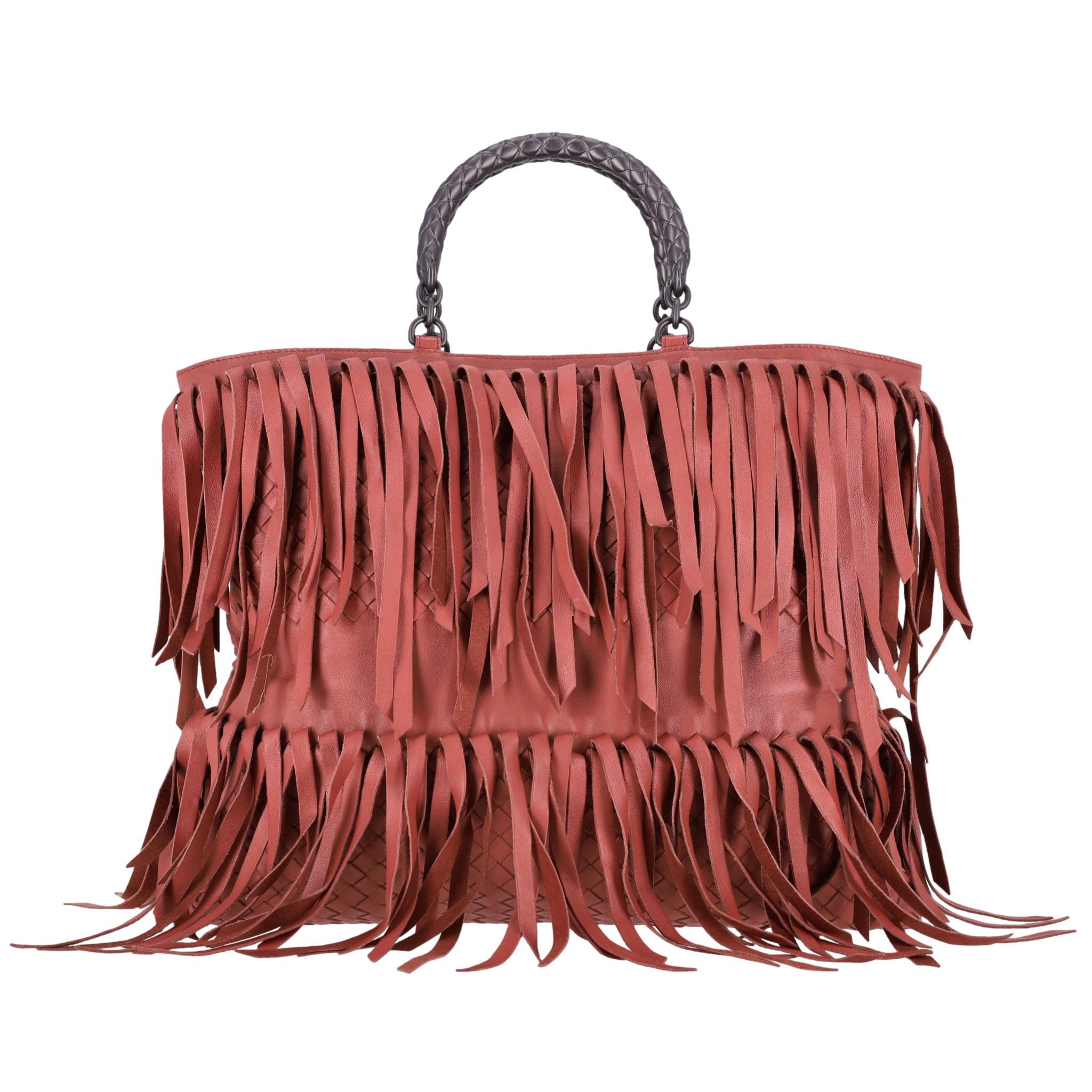 Sac cabas Intrecciato à franges Bottega Veneta

Grand sac en cuir rose rouille, orné de franges sur tout le pourtour.

Il est doté d'une double poignée roulée en cuir Intrecciato gris métallisé, emblématique de la marque.

Intérieur spacieux en daim